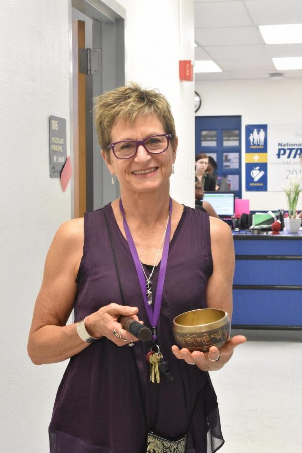 Mrs. Howard, holding the bell she commonly chimes during the Mindful Minute.