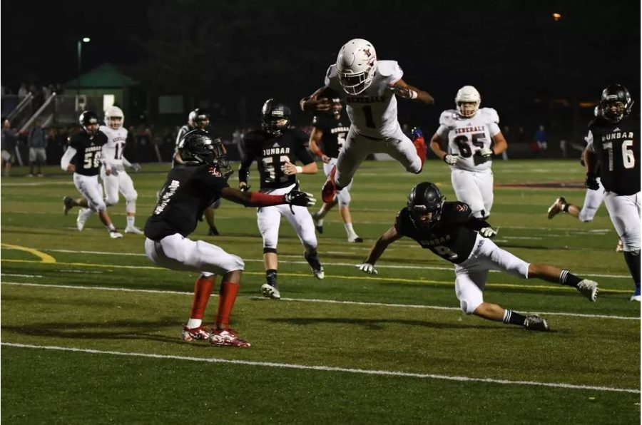 LEXINGTON, KY: Warren Wilson hurdles his way into the endzone against rival Paul Dunbar.