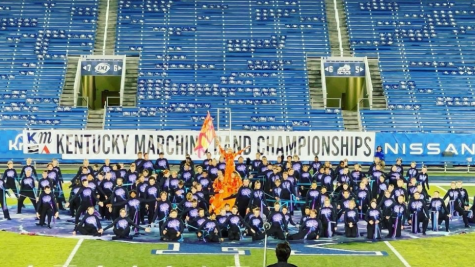 Jade Fitch, pictured in the orange, waves a flag during the post show of the Lafayette Bands State performance at Kroger Field
