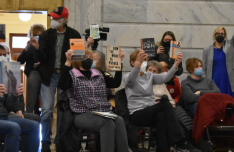 Rally attendees hold up books they fear may be banned with the passing of HB 14 and HB 18.