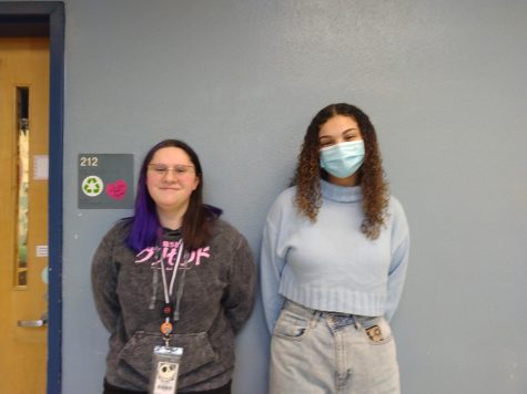 Bethany Stephens and Julia Burns stand together, one chooses to wear a mask and the other chooses not to