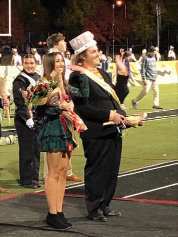 Homecoming King and Queen, Ryder McConaughey (right) and Amelia Mintu (left) wave to the football game crowd.