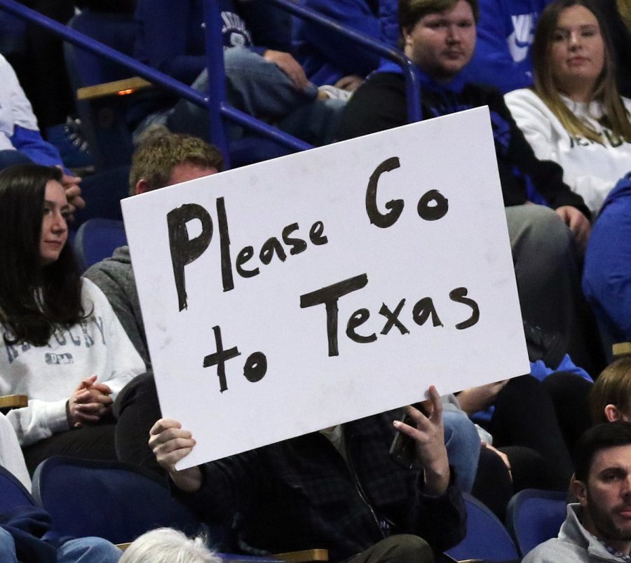 A fan at Rupp Arena holds a sign that reads Please go to Texas.