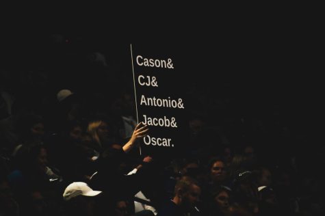 A fan at Rupp Arena on January 10 holds a black sign, with white text stating "Cason & CJ & Antonio & Jacob & Oscar."