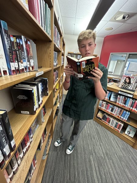 Logan Gwynn, a member of the book club and a sophomore at Lafayette, choosing a book in the Library for book club.