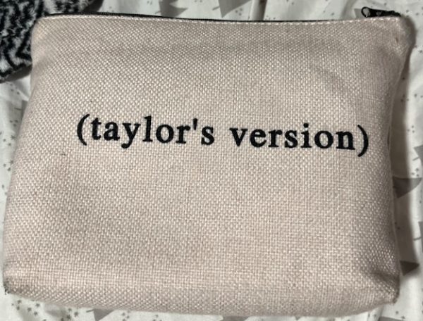 A canvas makeup bag that says, (Taylors version), talking about Taylor Swifts rerecorded songs.