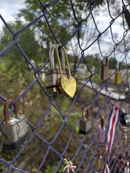 A heart shaped lock hung up on a purple fence for Locks for Addiction on Newtown Pike, Lexington, KY. Photo taken on Sunday, October 9, 2023.