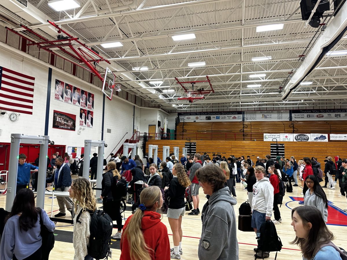 A long line of students in the morning during bag searches. Students have their bags ready to be checked by security staff. Photo taken on 3/25/24