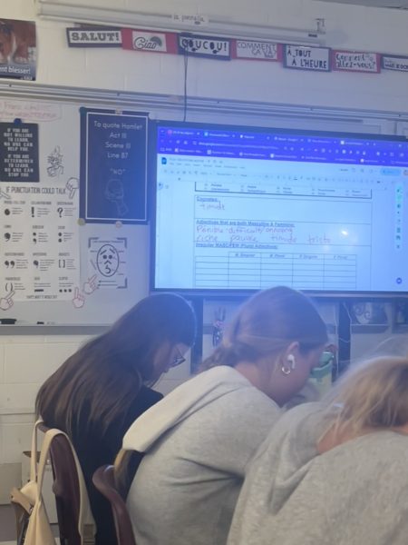 October 22, 2024, in Madam Brown’s class, students complete their work as she uses technology to demonstrate the lesson.