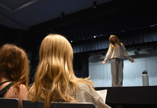 Student Cara Leo poses for an example of what auditioning on the Beiler Auditorium stage would be like on October 22, 2024, while her classmates Lorelei Brown and Ruby Wachter watch.