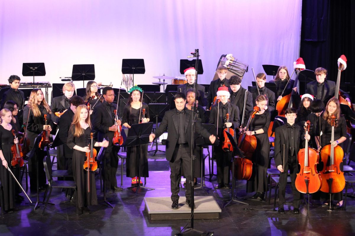 Aaron Breeck and the String Orchestra section concluding their performance after playing "To the Moon and Back" in Beeler Auditorium on December 12, 2024 at 7:30