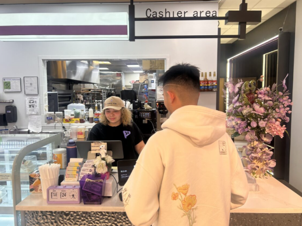 Photo of a person checking out food from Purple Yum, a local bakery. Photo taken on Feb. 25 2026.