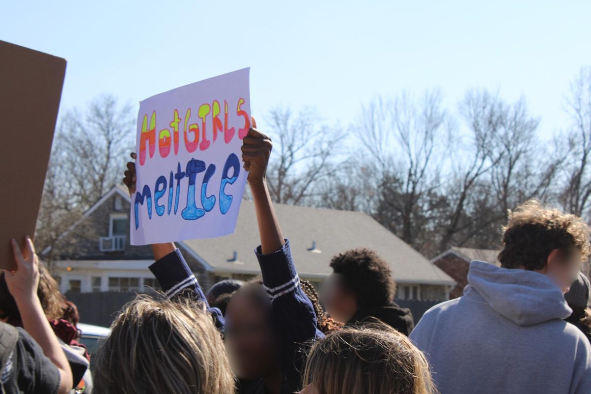 A student holding a sign that says "Hot Girls Melt ICE" in the walkout on February 13, 2026.