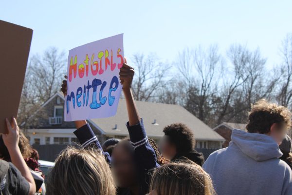 A student holding a sign that says "Hot Girls Melt ICE" in the walkout on February 13, 2026.