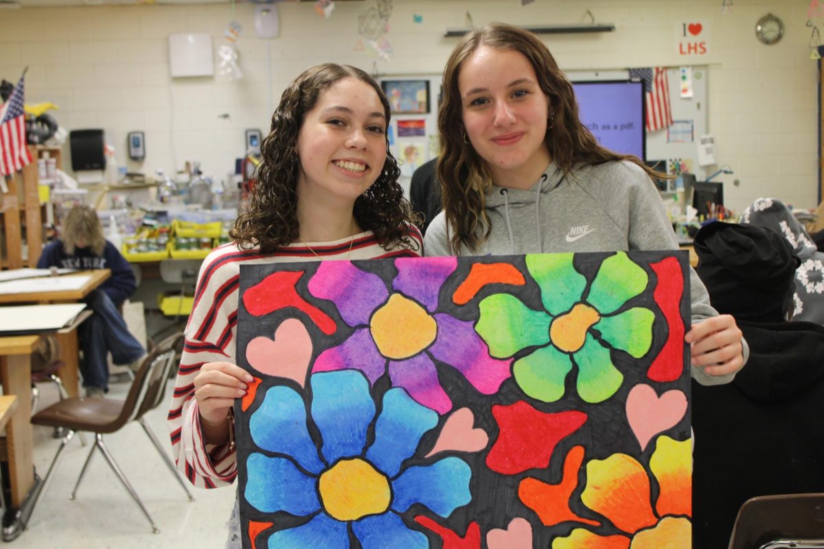 Marla Huber and Katelyn Adams are showing a painting done by Marla of colorful flowers on May. 21, 2026.